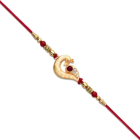 Golden Peacock Feather Rakhi with Red Thread & Kundan Accents
