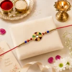 Elegant Multicolor Kundan Rakhi with Golden Floral Round Dial and Beaded Red Thread